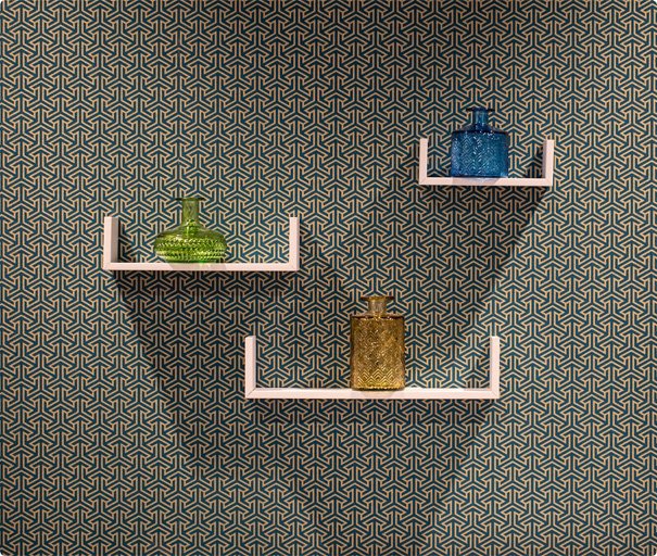 Decorative wall shelves with colorful glass vases mounted on patterned wallpaper.